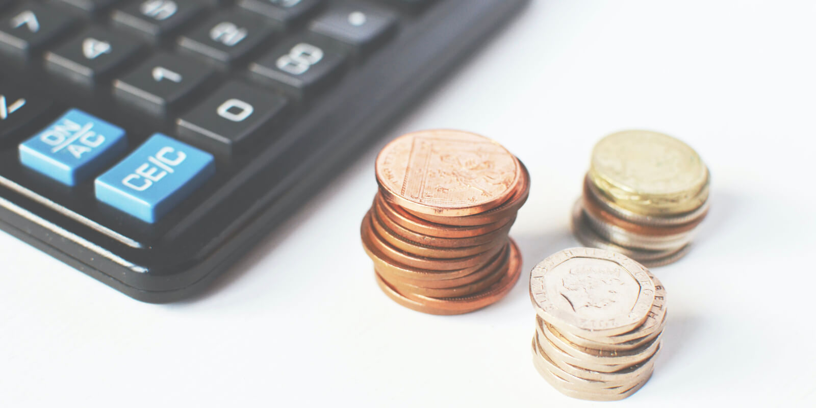 Calculator with piles of coins beside it